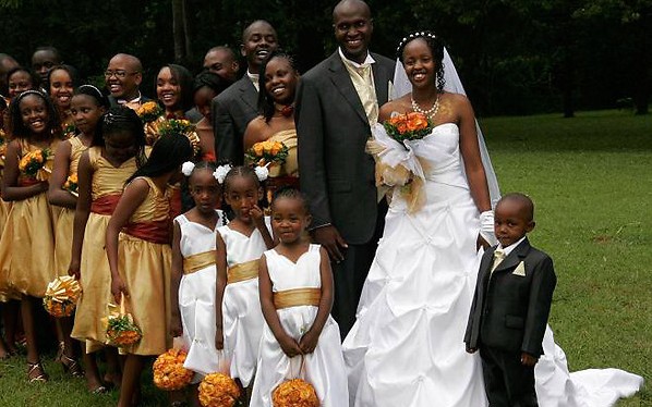 an African wedding ceremony with orange bouquets and flower corset flowergirls in golden dresses